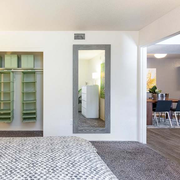 a bedroom with a large bed and a closet with a mirror