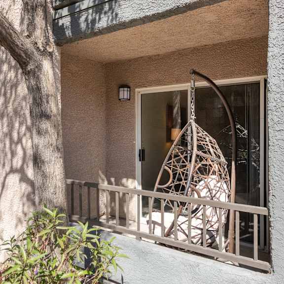 the front porch of an apartment building with a swing on it