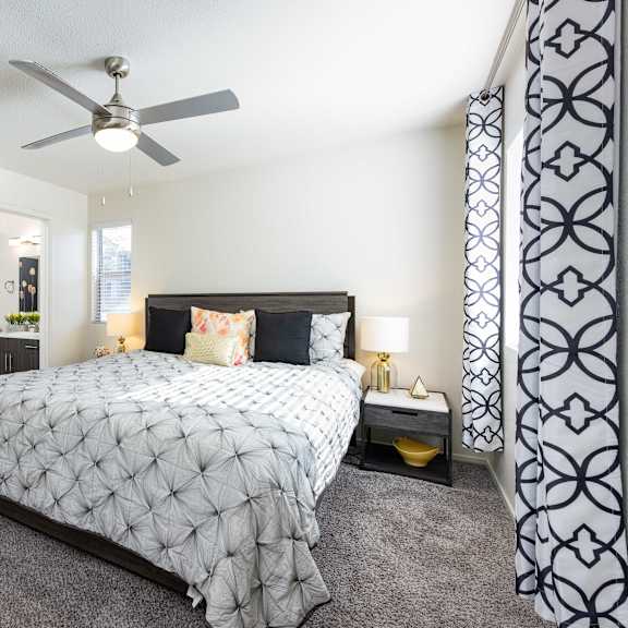 a bedroom with a bed and a ceiling fan