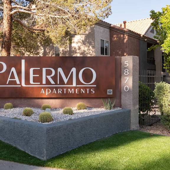 a sign for palermo apartments in front of a fence