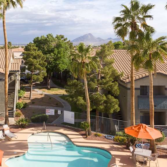 an aerial view of a pool at the resort with palm trees