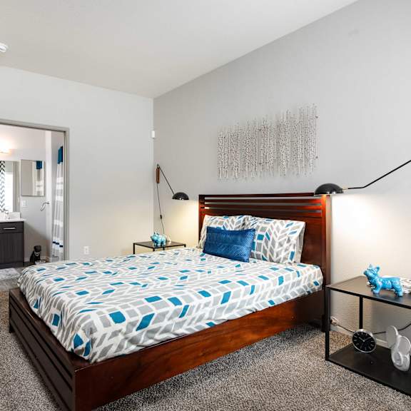 a bedroom with a bed and a dresser and a bathroom