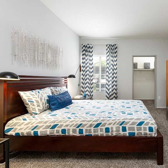 a bedroom with a bed and a dresser and a window