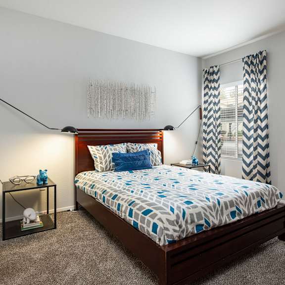 a bedroom with a bed and a window with curtains