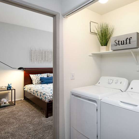 a white washer and dryer in a room with a bedroom