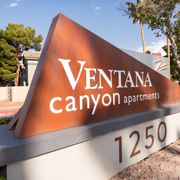 a sign that says ventana canyon apartments in front of a street