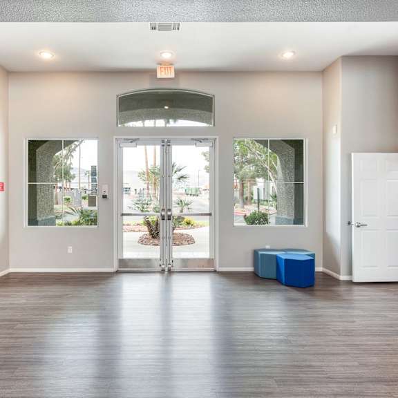 an empty living room with white doors and a hard wood floor