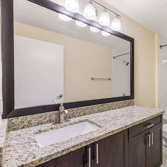a bathroom with a sink, mirror, and bathtub.