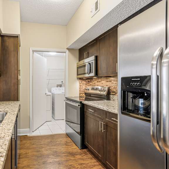 a kitchen with a sink, stove, and refrigerator.
