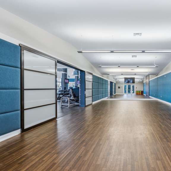 a long hallway with wood floors and blue patterned walls.