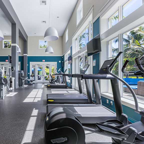 a gym with treadmills and exercise equipment.