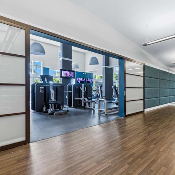 a gym with wooden floors and a variety of exercise equipment.