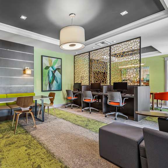 a modern office space with a green carpet and a variety of chairs and tables.