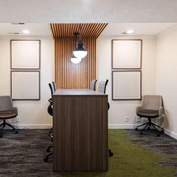 a conference room with a wooden desk and chairs