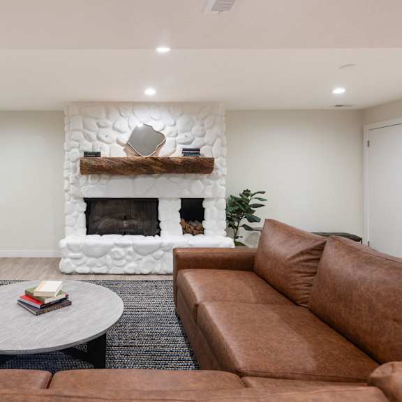 a living room with a couch and a coffee table and a fireplace