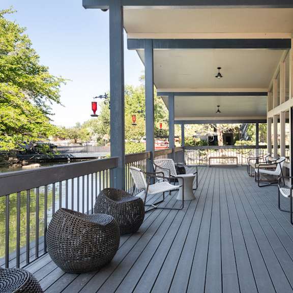 a covered porch with chairs and tables on it