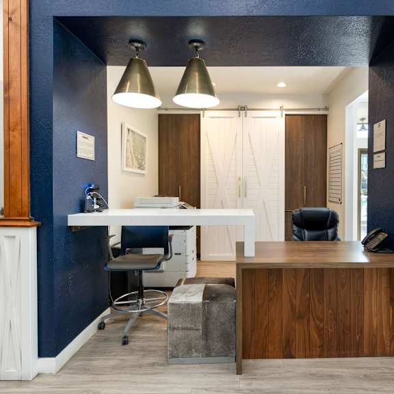 an office with a desk and a chair and a blue wall