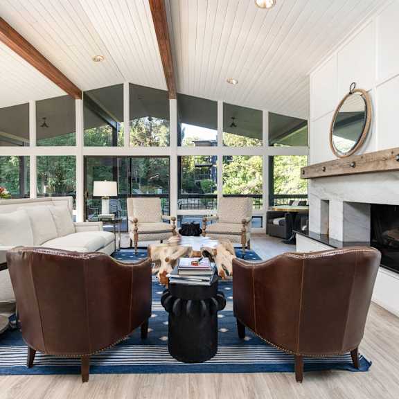 a living room with leather chairs and a fireplace