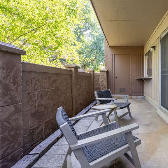 a patio with two chairs and a table on a balcony