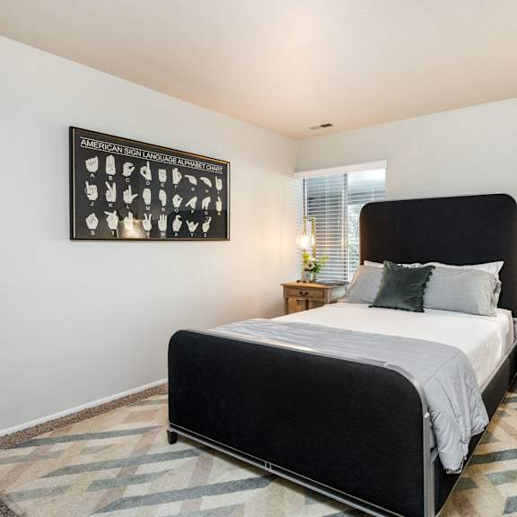 the bedroom has a large bed and a large window