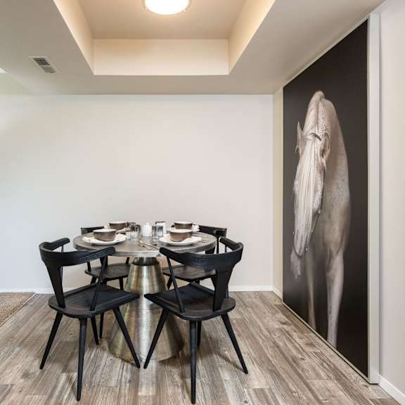 a dining room with a table and chairs and a large wall mural of an elephant