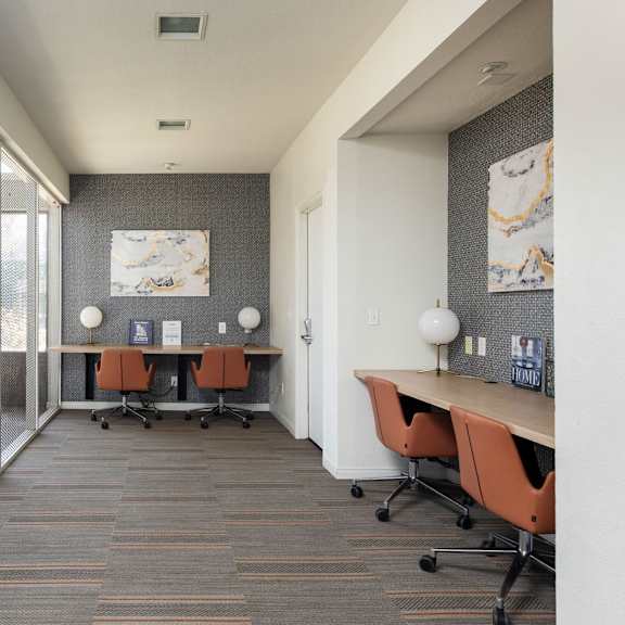a conference room with a desk and chairs and a window