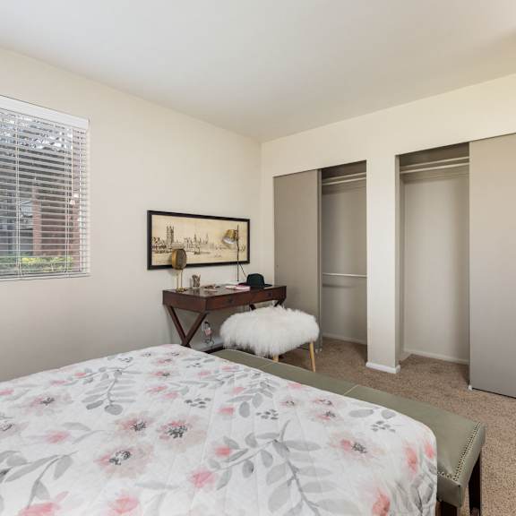 a bedroom with a bed and two closets and a window