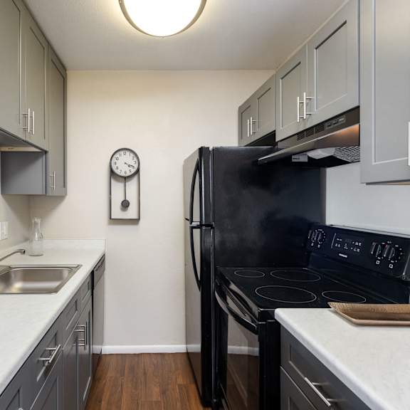 a kitchen with black appliances and white counter tops