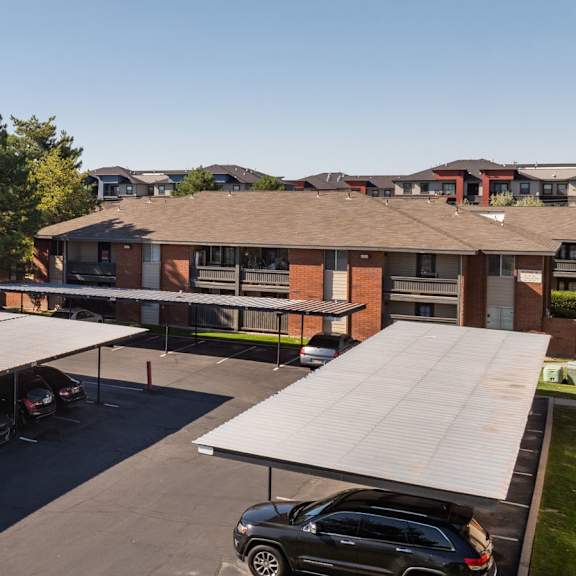 a roofed parking lot in front of a building