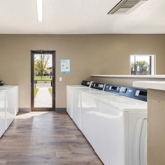 a row of washers and dryers in a laundry room