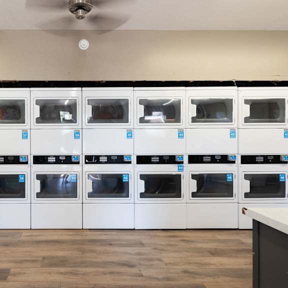 the laundry room is full of white cabinets and appliances