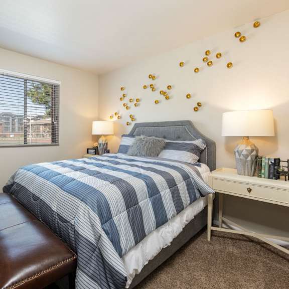 a bedroom with a blue and white bed and a window