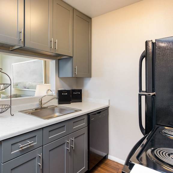 a kitchen with a sink and refrigerator and a window