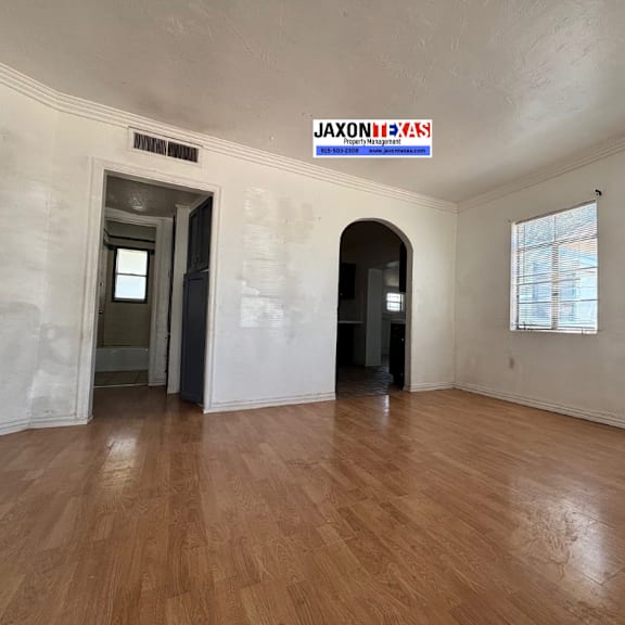 a room with wooden floors and a sign that says "jaxontexas" on the wall.