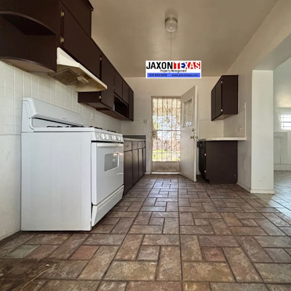 a kitchen with a white oven and brown cabinets.