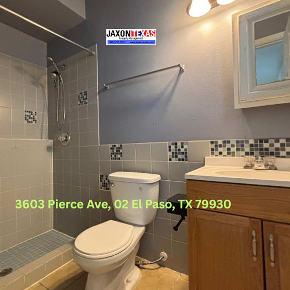 a bathroom with a toilet, sink, and shower.