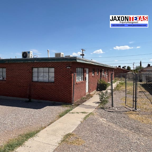 a red brick building with a white window and a sign that says jaxonilexas.