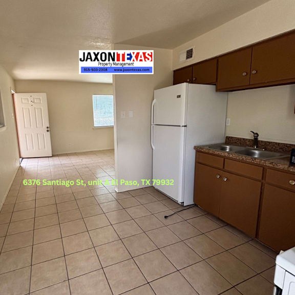 a kitchen with a white fridge and brown cabinets.