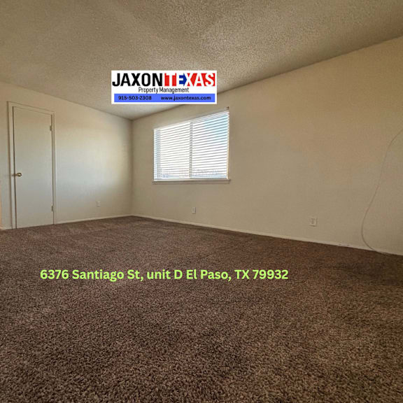 a room with a carpet floor and a door, with a sign that says "jaxon exas property management".