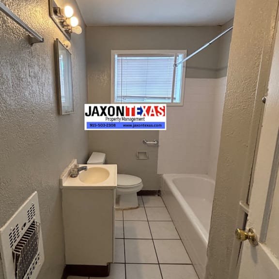 a bathroom with a toilet, sink, and bathtub.