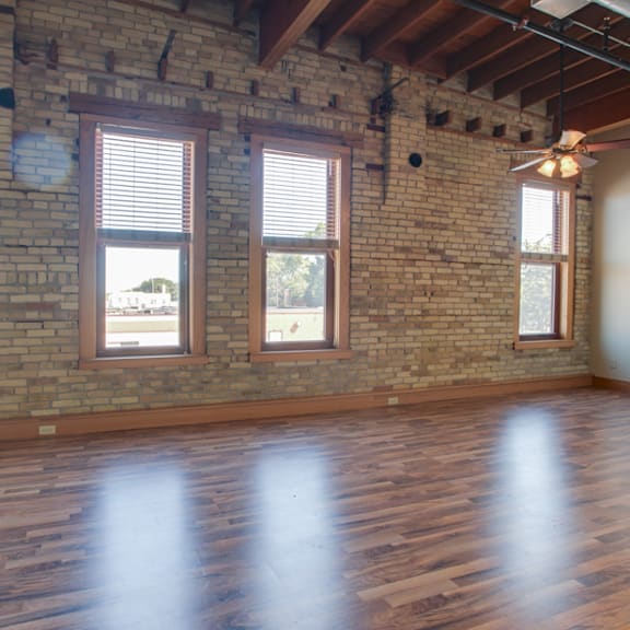 a room with wooden floors and a brick wall.