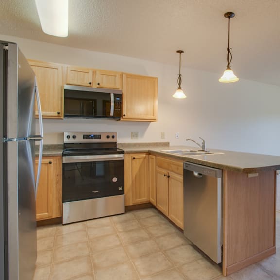 a kitchen with wooden cabinets and stainless steel appliances.