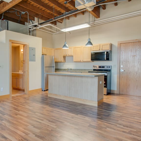 a kitchen area with wooden floors and a counter.