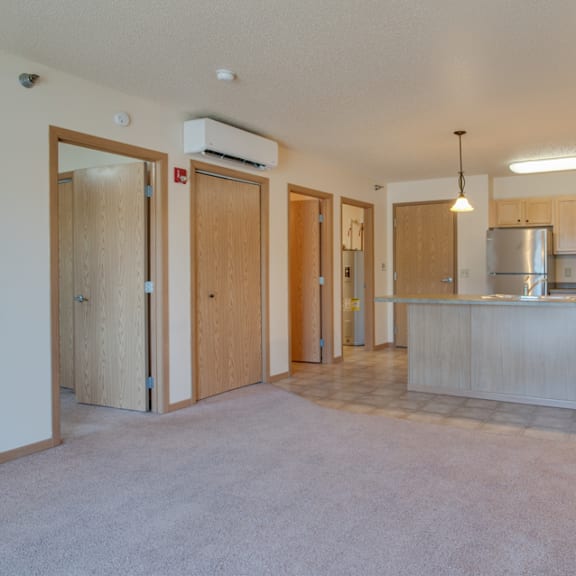 a kitchen area with a refrigerator, cabinets, and a countertop.