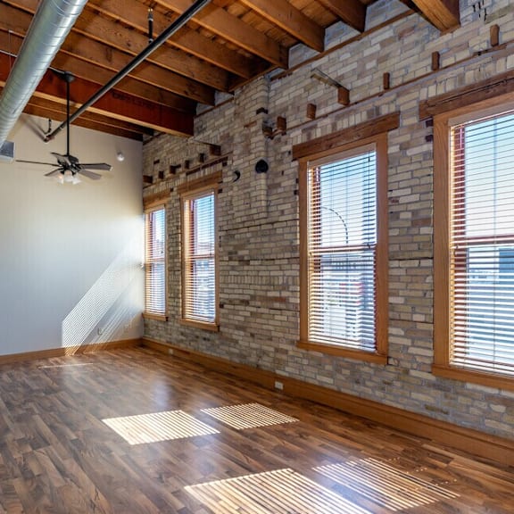 a room with wooden floors and a brick wall.