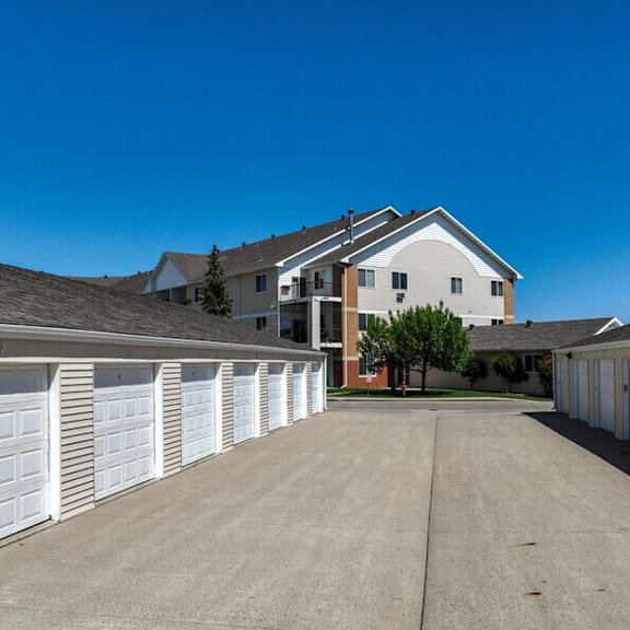 a row of white garage doors in front of a house.