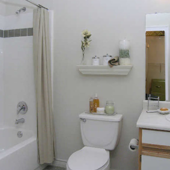 a white toilet sits next to a white sink in a bathroom.