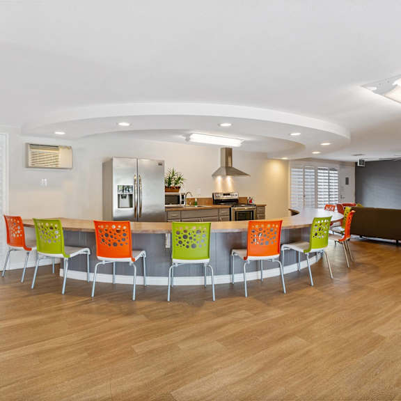 a conference room with a table and chairs and a kitchen at terramonte apartment homes, pomona, ca