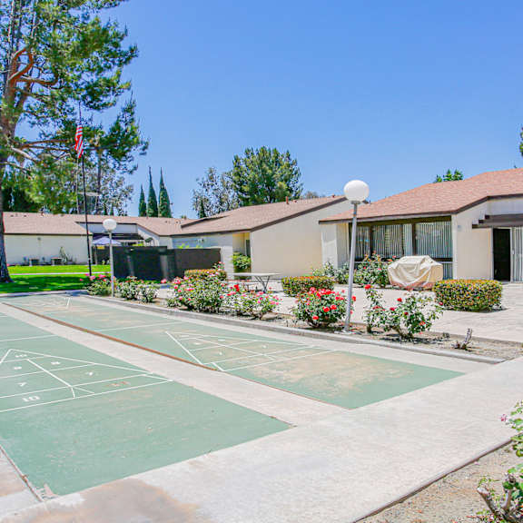 a basketball court is located in the middle of a courtyard with a building in the background.