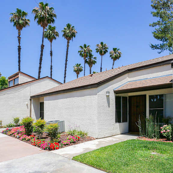 a house with a brown roof and a white wall with a brown door and a window.